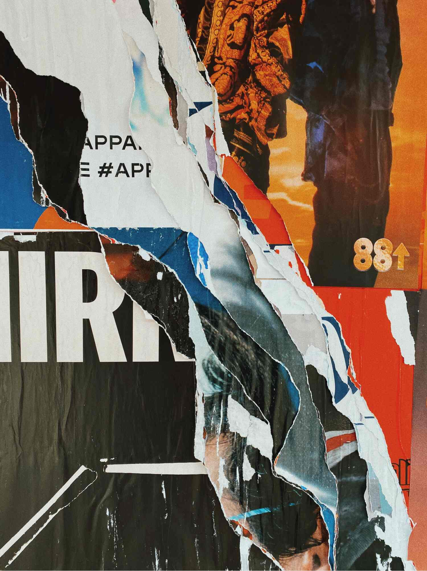 A collage of layered posters on a wall, with a large rip running from the top down to expose the different layers underneath. The numbers '88' with an arrow pointing up is printed on the right and big, bold white lettering against a black backdrop on the left